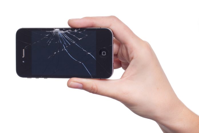 cellulare indistruttibile - nella foto una ragazza tiene tra le dita un cellurare con il vetro tutto rotto