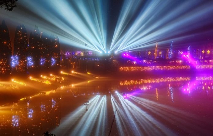 Altra Scena Piombino Festival - un lungomare visto dall'alto con tutta la spiaggia illuminata e dei raggi azzurri che illuminano il cielo e si riflettono nel mare creando un effetto stella