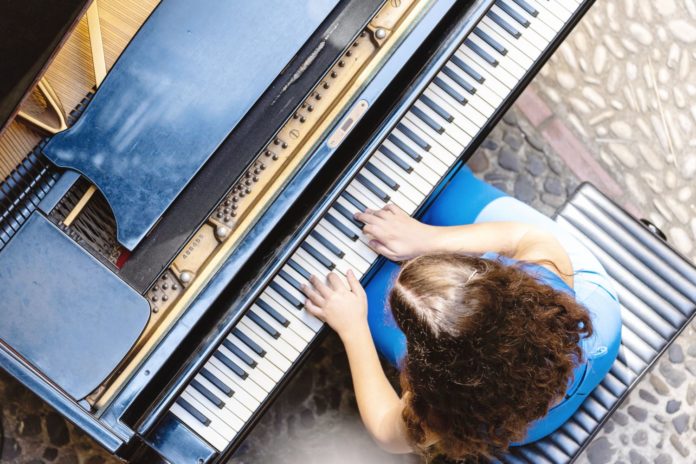 Piano City Palermo, un pianoforte con una ragazza che lo suona, veduta dall'alto