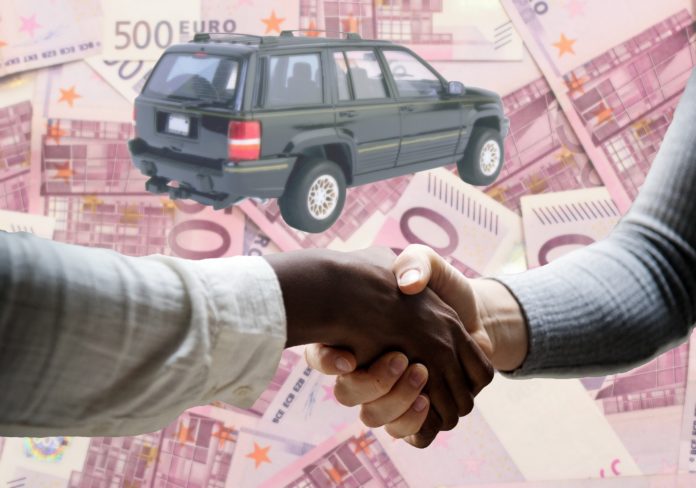 Ecobonus auto usate nella foto due mani che si stringono, una macchina e tante banconote da 500 euro