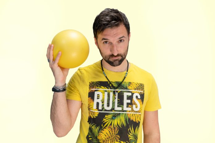 bathala - riccardo inge indossa una maglietta gialla e tiene nella mano destra un pallone giallo