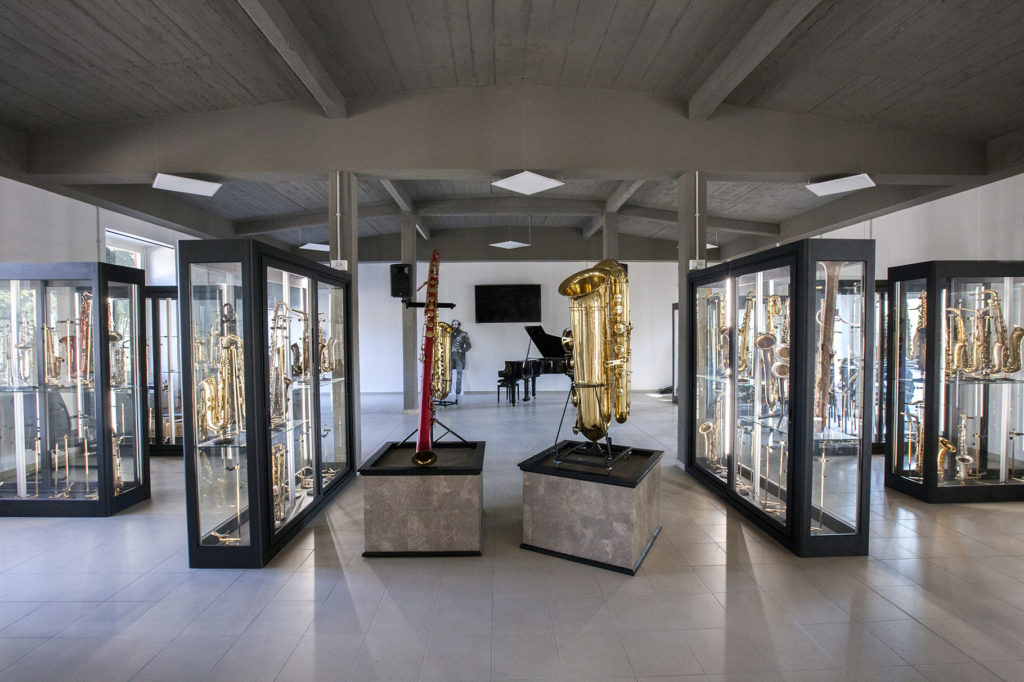 una sala del museo del saxofono con divwerse bacheche vetrate con tanti saxofoni esposti