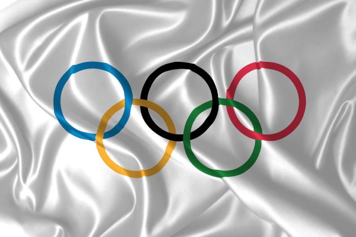 atleta italiano paralimpico, disabilità, forza. Nell'immagine i cinque cerchi olimpici disegnati su un lenzuolo di seta bianco.