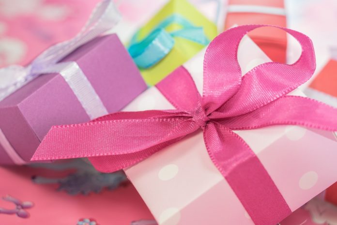 regali di natale impacchettati con carta rosa e fucsia, con dei grandi fiocchi