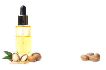 Olio di argan, proprietà, benefici, bellezza, pelle, capelli, salute, benessere. Sulla sinistra una boccetta di olio con due semi di argan.