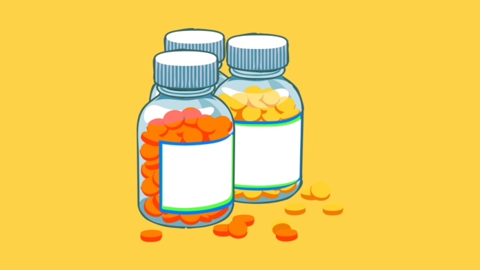 vitamina b12, proprietà, benefici, integratori alimentari. Sfondo giallo con tre flaconcini contenenti delle pastiglie di colore giallo e arancione.