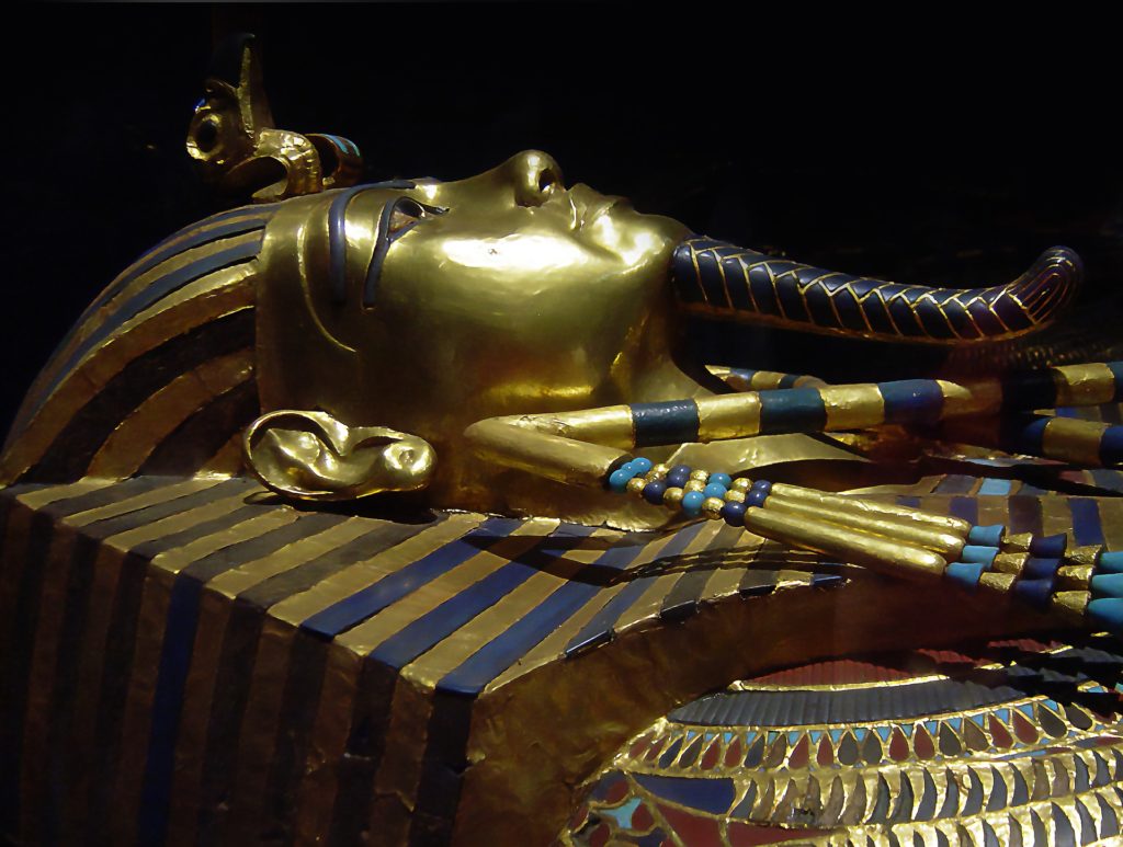 Primo piano di profilo della maschera funeraria di tutankhamon , tutta dorata cn intarsi di pietre azzurre