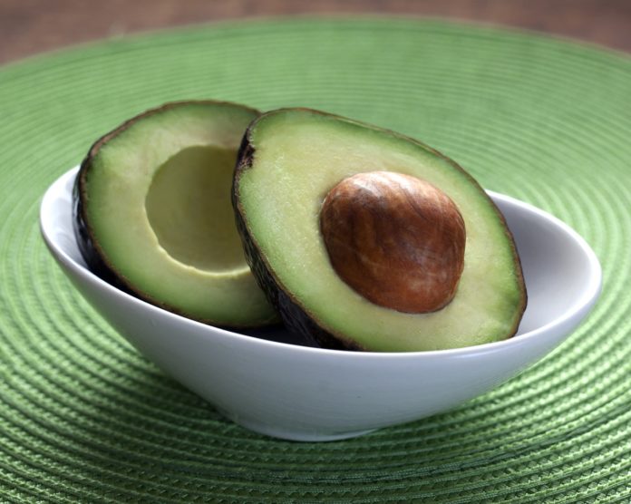 Vitamina B6, proprietà , benefici, alimenti, alimentazione. Un avocado tagliato a metà alll'interno di una ciotola in vetro.