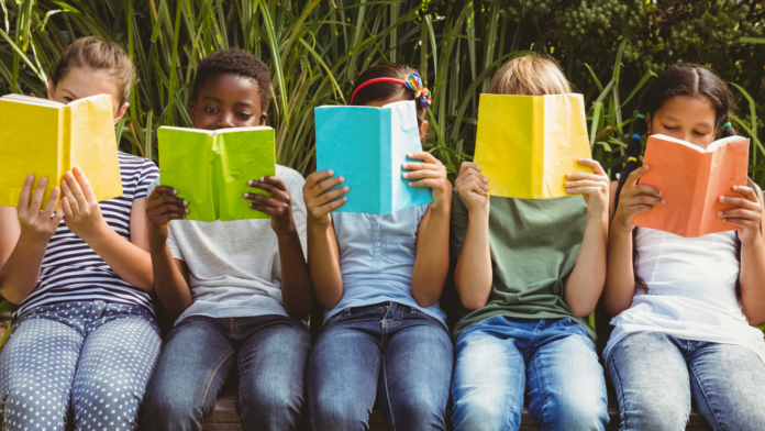 Book Pride, a Milano la fiera dell'editoria indipendente 5 ragazzini seduti su una panchina leggono libri colorati