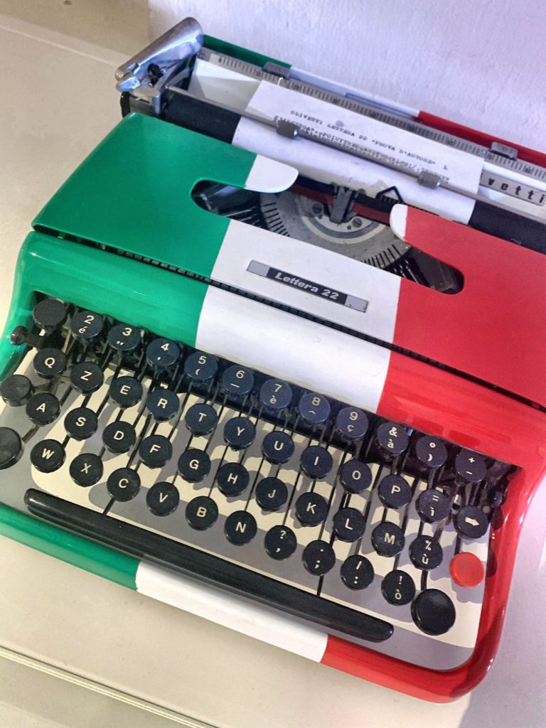 locandina di Ivrea capitale italiana del libro 2022. la macchina da scrivere olivetti lettera 22 con i colori della bandiera italiana