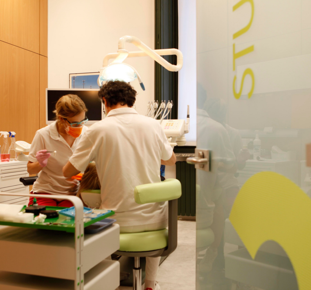 Longevità invecchiamento e stile di vita anche la salute orale influisce nella foto una visita dentistica su un paziente in poltrona con medico e assistente