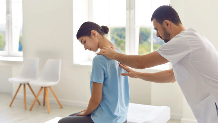 Kinesiologia, muscoli, ansia, stress, equilibrio. Un ragazzo che massaggio il collo ad una ragazza seduta su un lettino