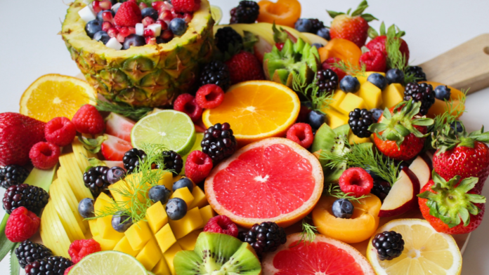 Nutraceutica, alimenti, salute, benessere, integratori, estratti, piante. Un tavolo pieno di frutta e agrumi con colori molto accesi.
