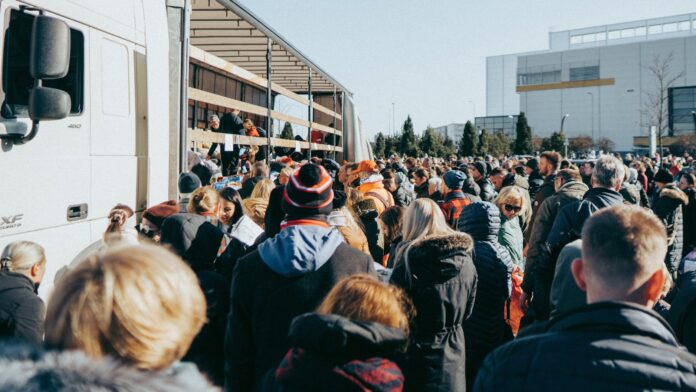 Guerra Ucraina - tanti profughi ucraini davanti a dei tir carichi di valige e pacchi