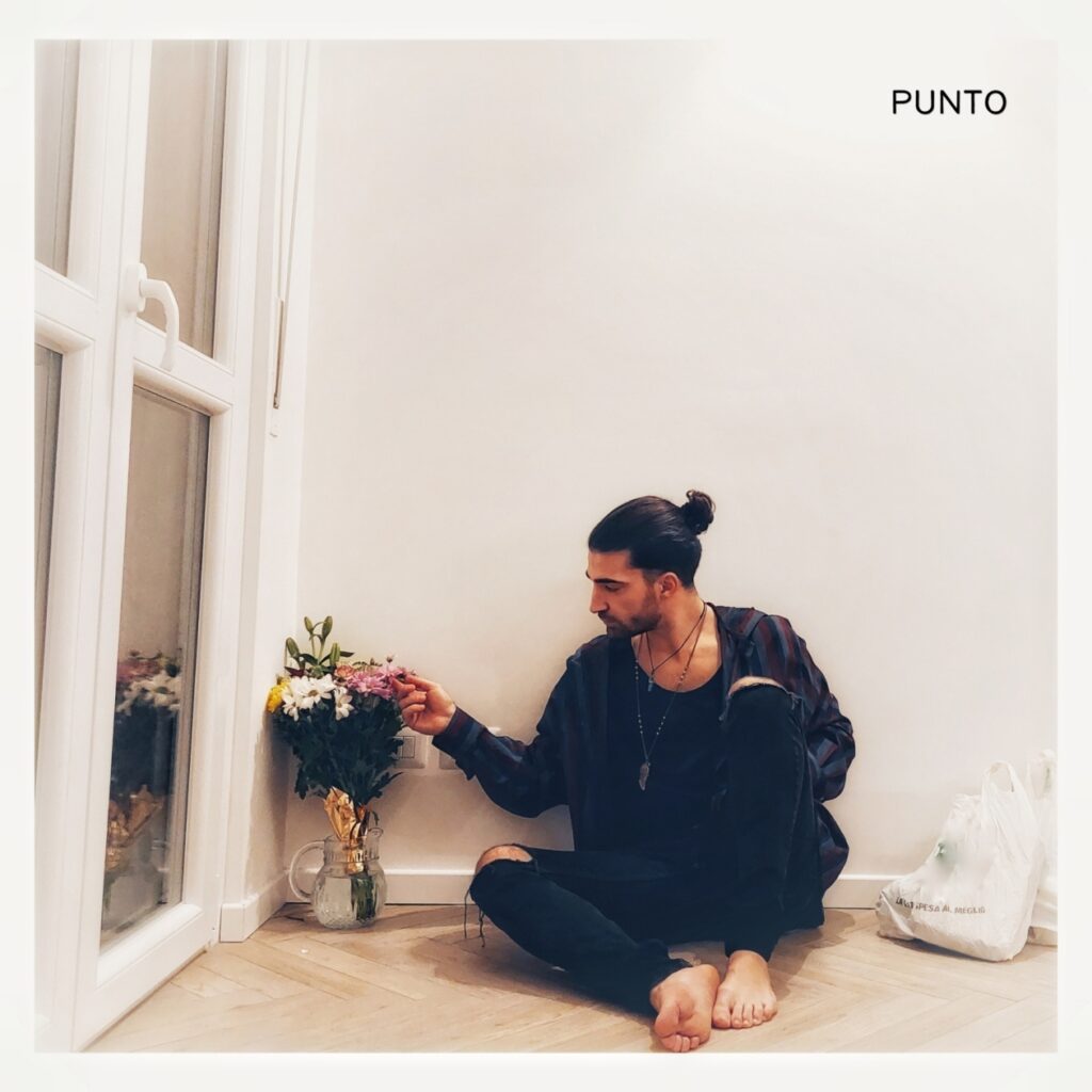punto - la copertina del singolo che ritrae malavoglia, vestito di nero, seduto per terra, intento ad accarezzare un mazzo di fiori