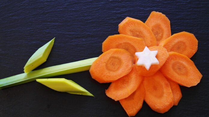 la dieta dei cinque colori: un fiore formato da un gambo di sedano e da una carota a fettine rotonde