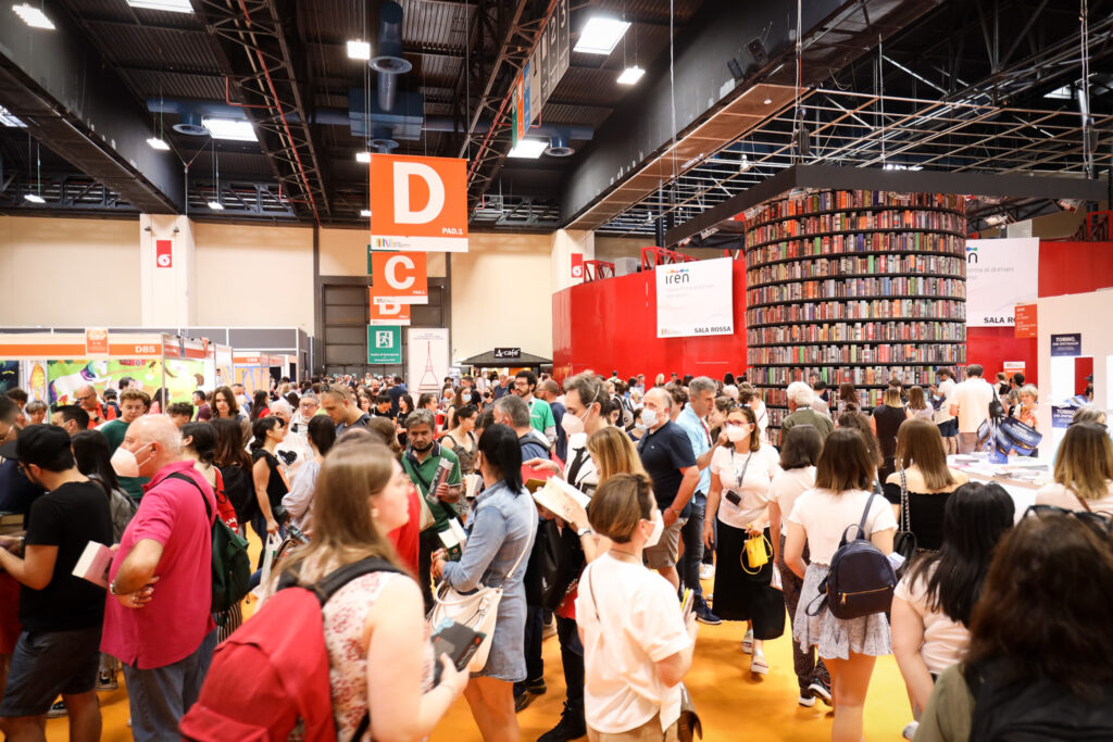 vista interna del salne accanto alla torre di 4 metri di libri e centnaia di persone intorno