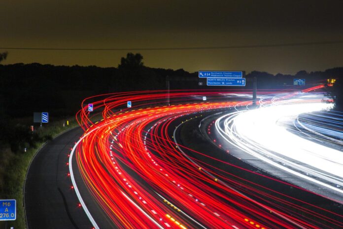 alterpop - autostrada notturna, illuminata dai fari delle macchine