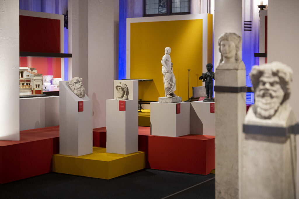 invito a Pompei- foto che ritrae diverse statue in mostra. In primo piano ci sono un volto maschile e uno femminile, in secondo piano altri due volti maschili, un bambino in bronzo ed un corpo maschile. 