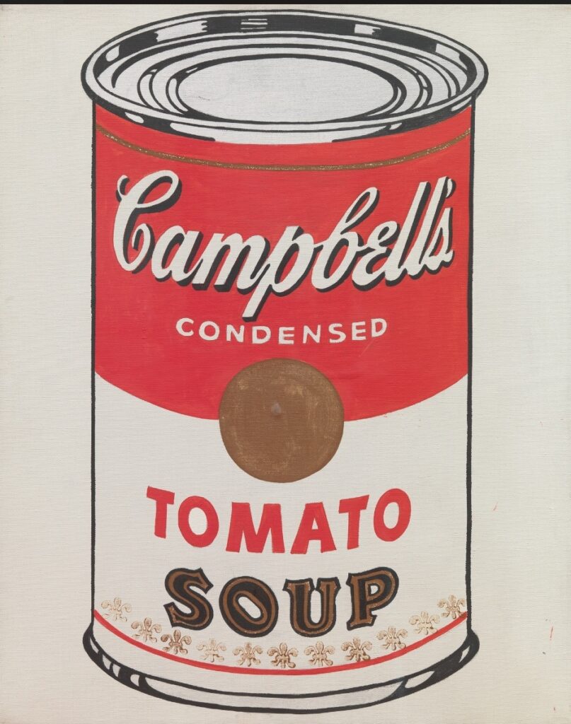 una lattina Campbell scritta bianca etichetta rossa con scritta tomato in rosso e soup in marrone scuro