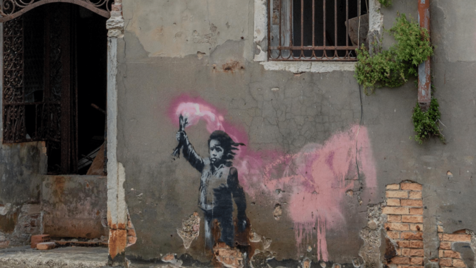 opera di banksy a Venezia bambina con torcia rosa in laguna