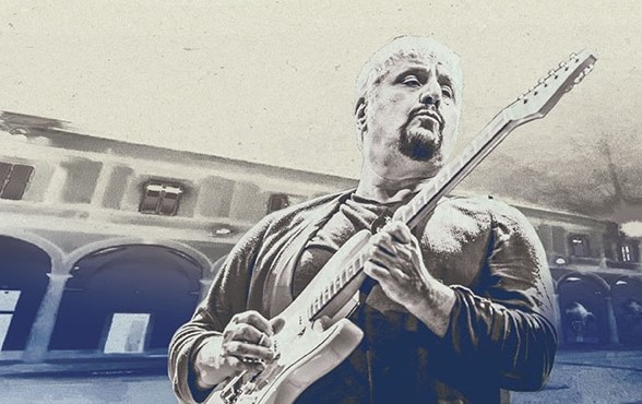 PNA Fondazione Pino Daniele - nella foto un disegno a carboncino ritrae pino daniele con la chitarra in mano e dietro di lui un palazzo con tanti archi