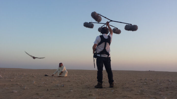 collinarea festival del suono - un panorame lunare con una ragazza vestit di bianco, inginocchiata e un uomo che tiene nella mano destra un grosso drone con dei microfoni anti fruscio