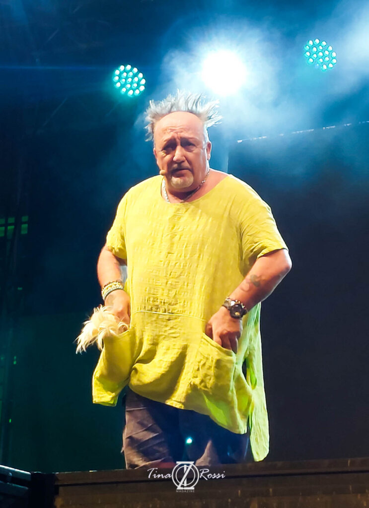 max cavallari sul palco, indossa un camicione giallo