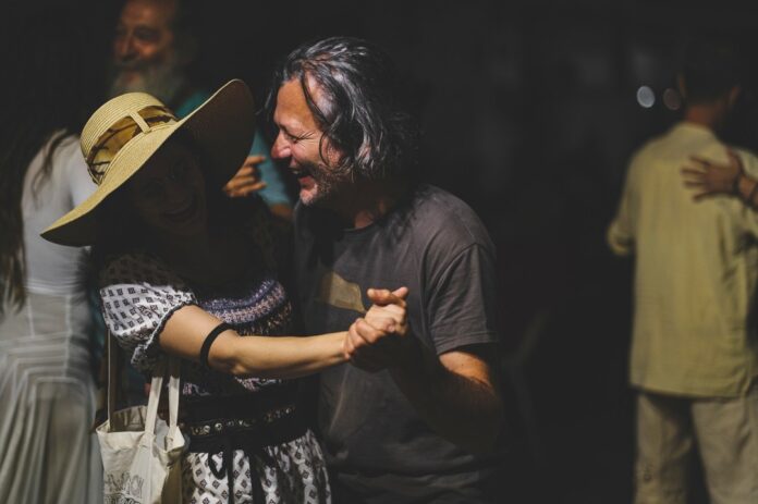 momenti di festa durante lo sponz coultura 2022 due persone ballano sorridenti lei con cappello di paglia di sera