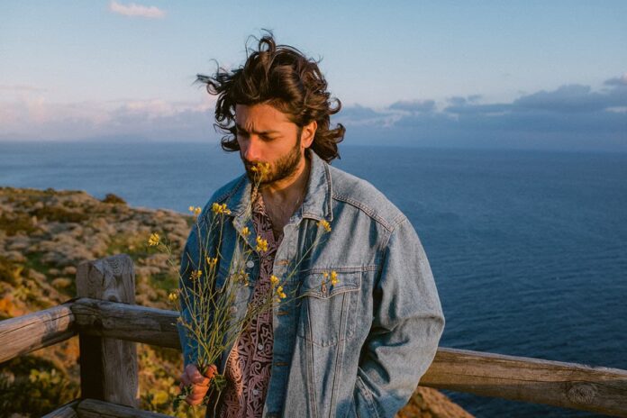 fandango - cordio indossa un giubbotto di jeans, sullo sfondo il mare della sicilia