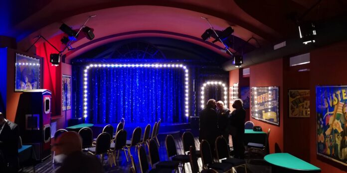 interno visibile durante open day con palco illuminato sipario blu con luci illuminanti intorno