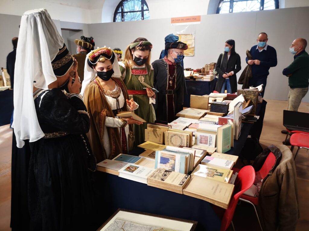 persone in costume medievale intorno a uno stand di libri immagini edizione 2021