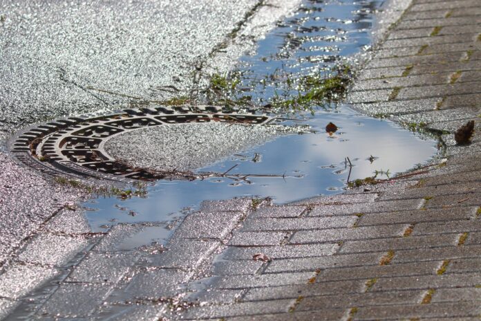 metano - un tombino di strada rotondo con dell'acqua stagnante