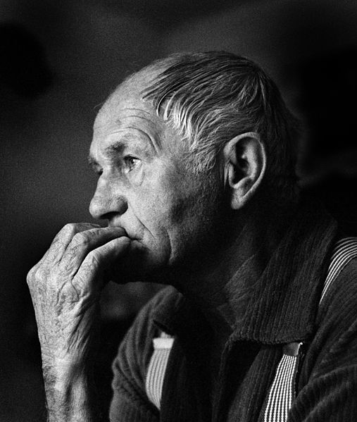 compiti per casa, nella foto in bianco e nero, di profilo, l'autore del libro, anziano, quasi calvo, ha un'espressione di riflessione con la mano davanti alla bocca