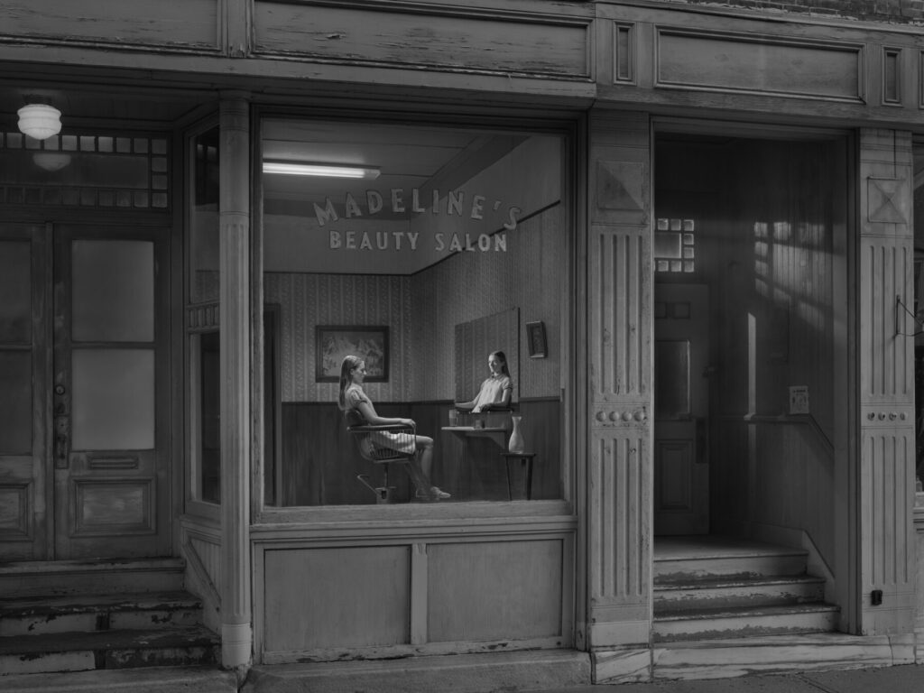 una donna in vetrina seduta dentro un salone di bellezza foto in bianco nero