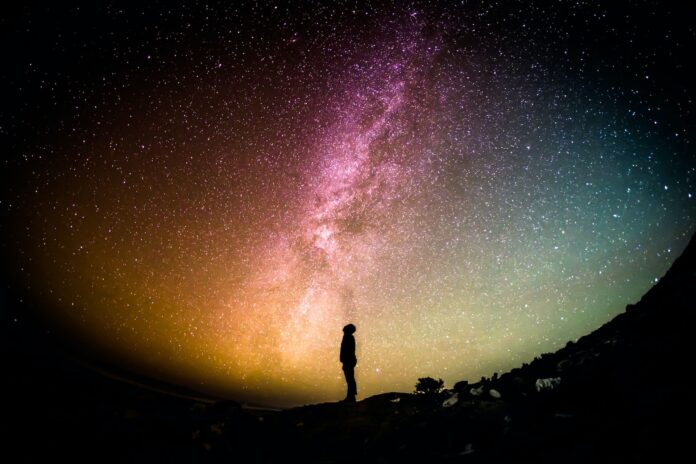 starboz: un uomo guarda un cielo illuminato dalle stelle