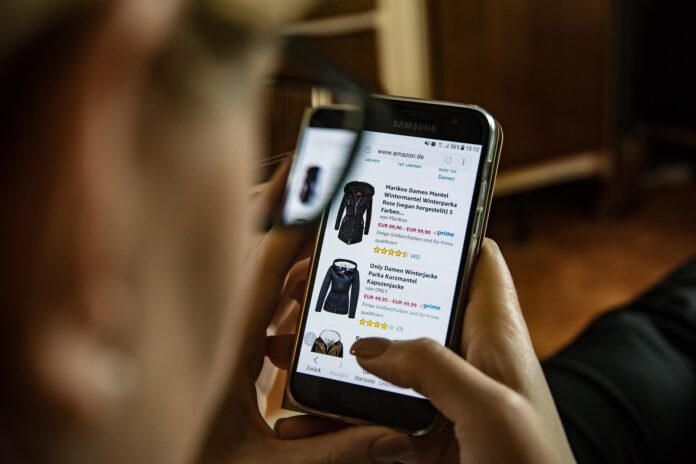 shopping - una ragazza sta guardando sullo smartphone un sito di abiti in vendita