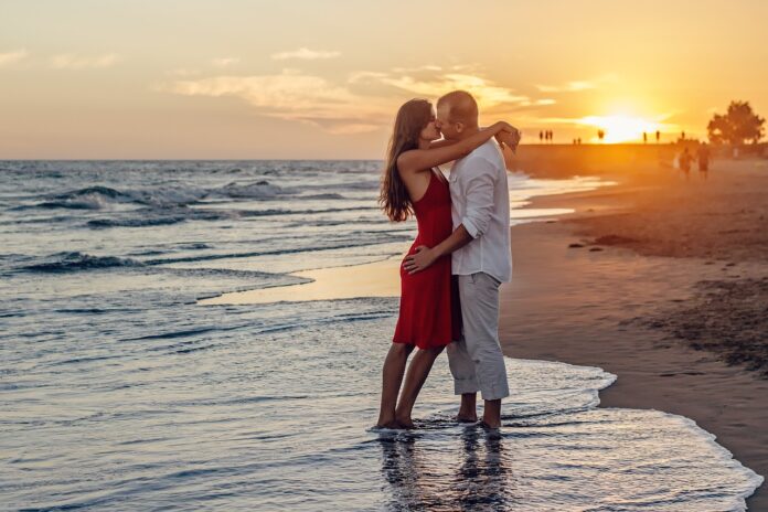 come baci bene - due giovani che si baciano sulla spiaggia al tramonto