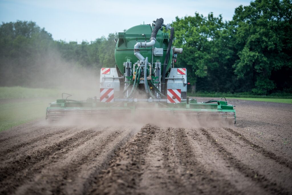 Crisi settore agricolo - un trattore che sparge fertilizzante in campo