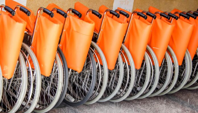 Disabilità e diritti - nella foto tante carrozzine per disabili, di coloro arancione, messe in fila