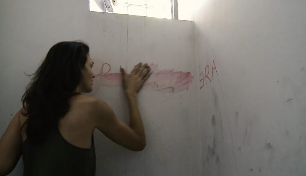 25 novembre una donna rinchiusa in una stanza cancella una scritta rossa 