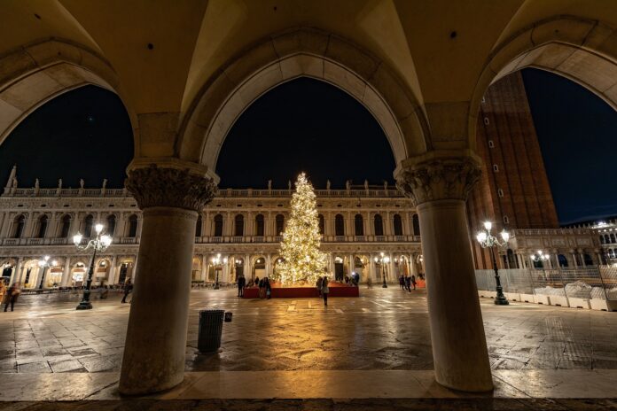 Venezia Natale - dagli archi del palazzo ducale si vede un grande albero di natale illuminato