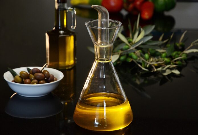 un'ampolla d'olio delle olive e un ramo di olivo