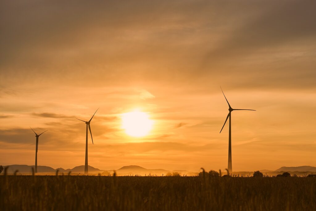 pale eoliche in un campo al tramonto