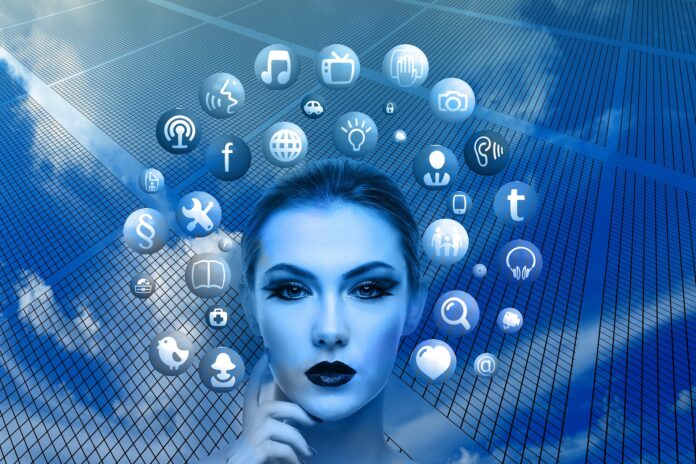metaverso - nella foto il volto virtuale di una donna dipinto di blu, intorno a lei tante palline blu e bianche, ognuna con un simbolo di un social network