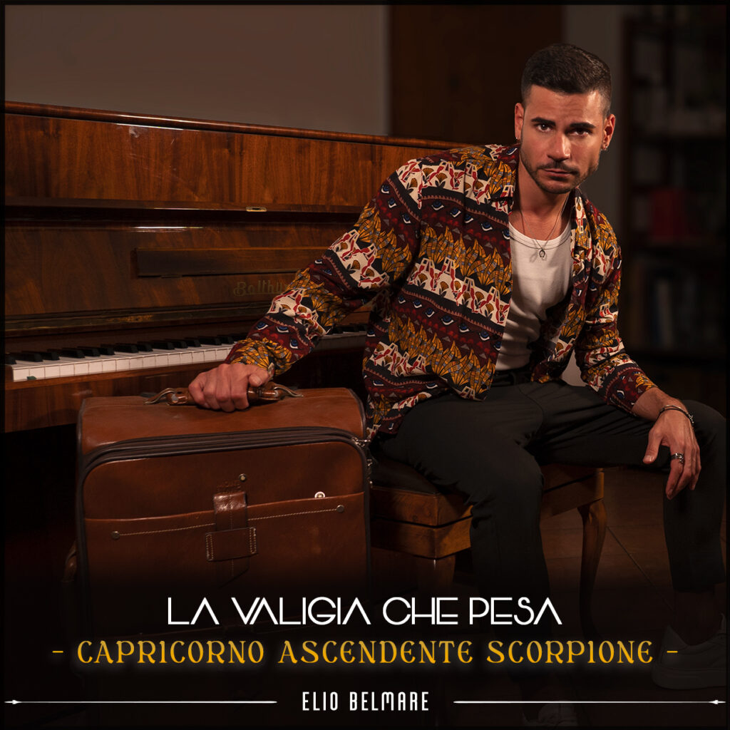 elio belmare - la copertina del nuovo singolo che lo ritrae saduto su uno sgabello, appoggiato a un pianoforte verticale, con una valigia di pelle marrone