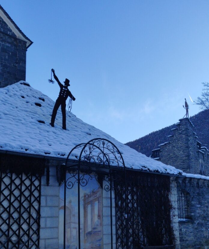 uno spazzacamino sul tetto innevato