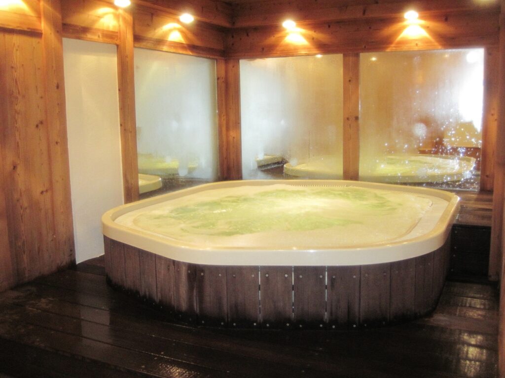 Una enorme vasca da bagno in un centro termale con tanti specchi e luci