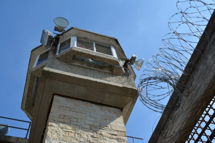 protesta carcere Vercelli: una torretta di guardia esagonale di un carcere e un muro con del filo spinato sulla sommità