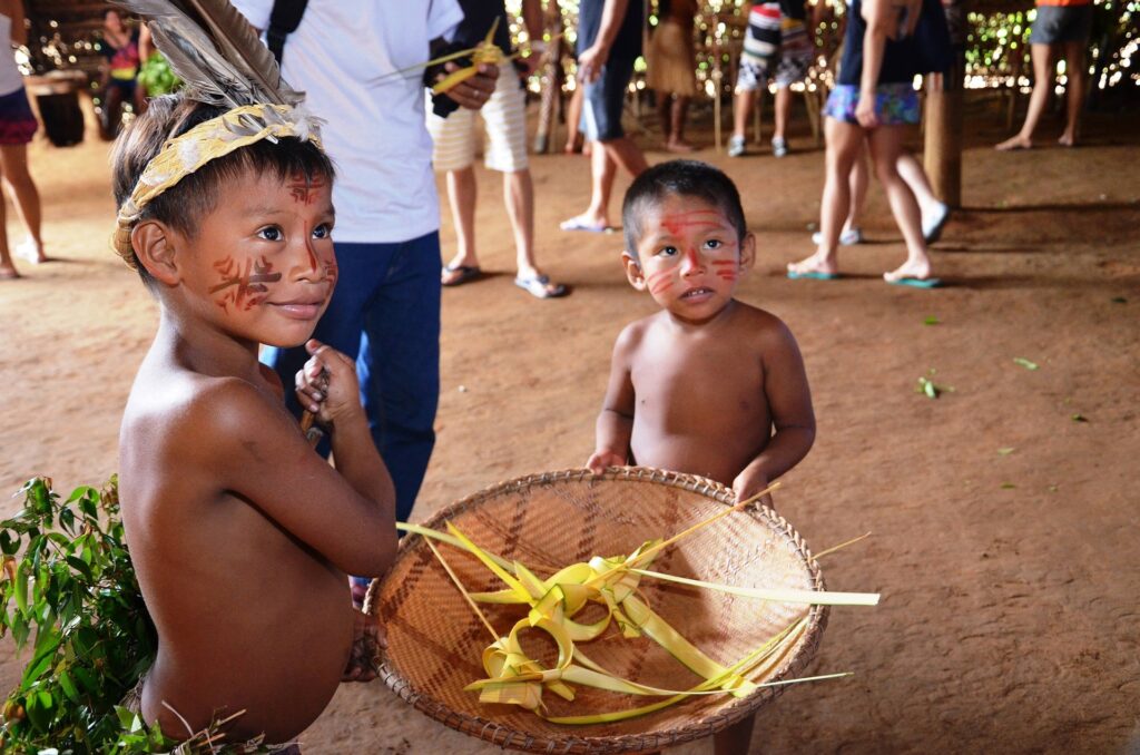 #10dicembre diritti umani giornata mondiale - nella foto due bambini indigeni dell'Amazzonia sono in ginocchio per terra vicino a un cesto di vimini